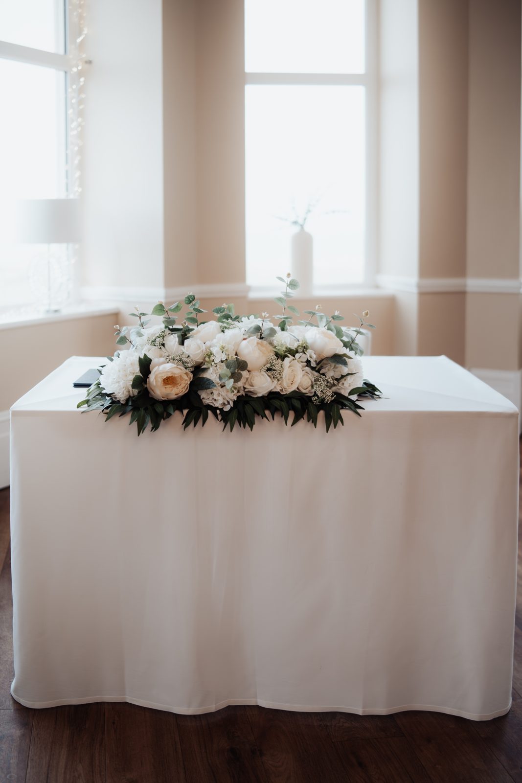 Ivory rose and eucalyptus table arrangement